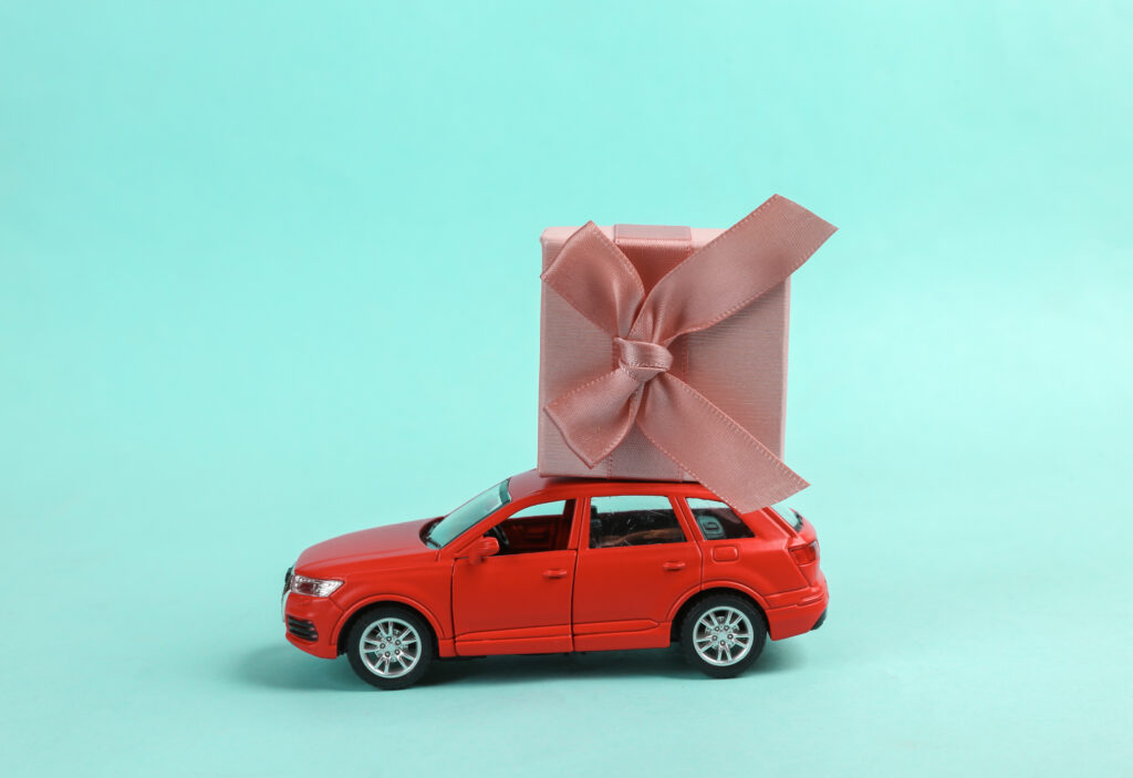 international gift reseller toy car model with a gift box on blue background.