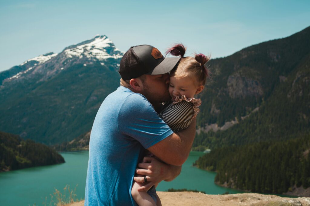 father's day gift guide dad kissing daughter against mountain background