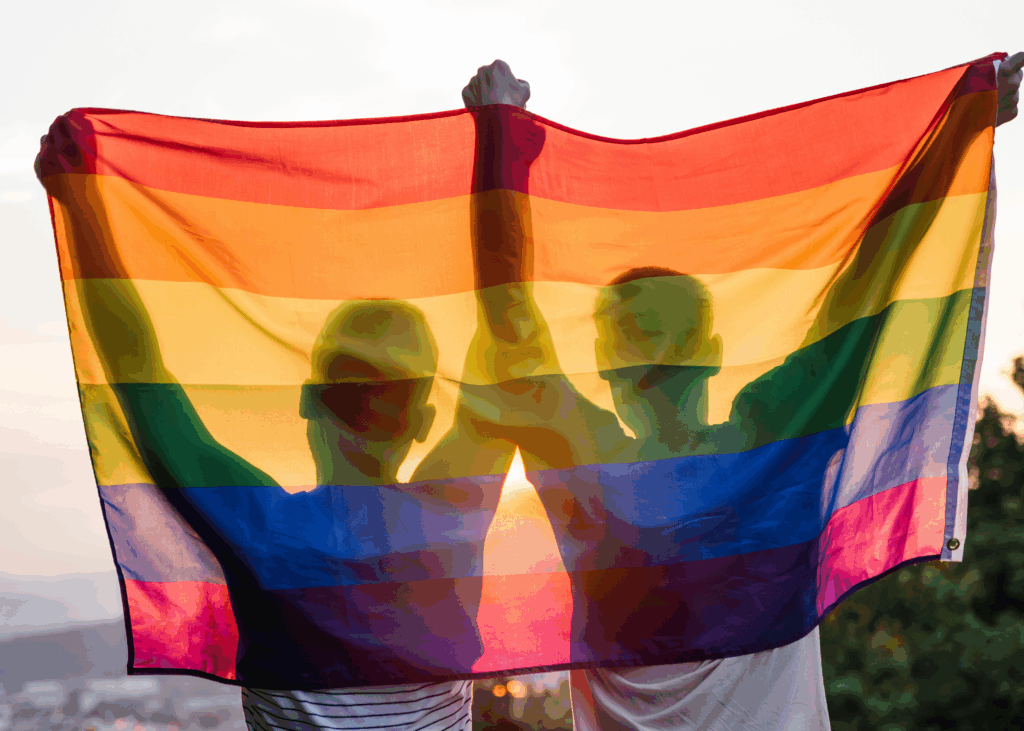 two men holding up the pride flag 